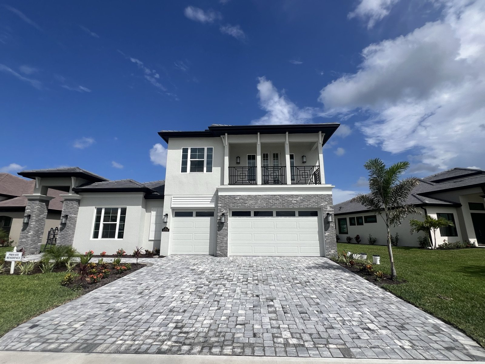 Gray paver driveway in front of a two-story house, built by Groundworks in Brevard County