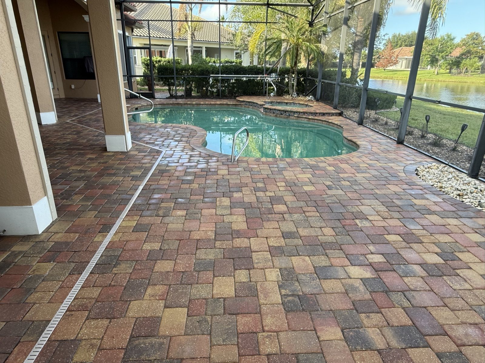 Screened pool deck laid in multicolored concrete pavers, a Groundworks job in Brevard County